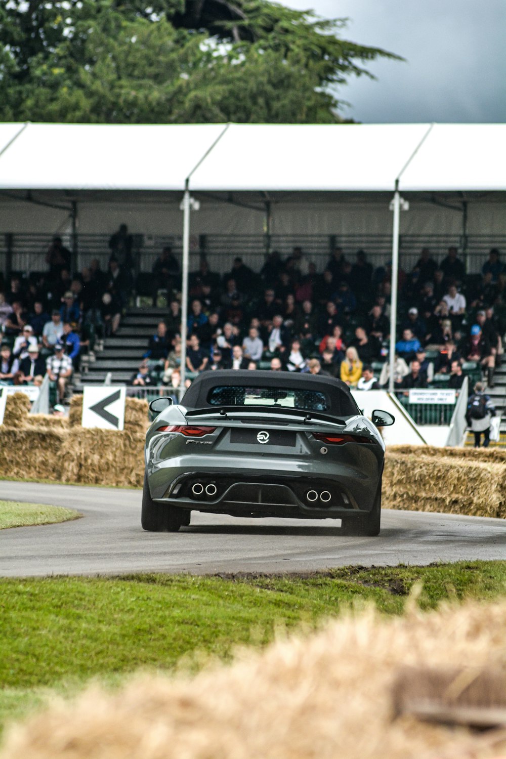 a car driving down a race track in front of a crowd