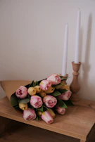 Elegant arrangement of tulips in soft pastel shades displayed on a rustic wooden table.