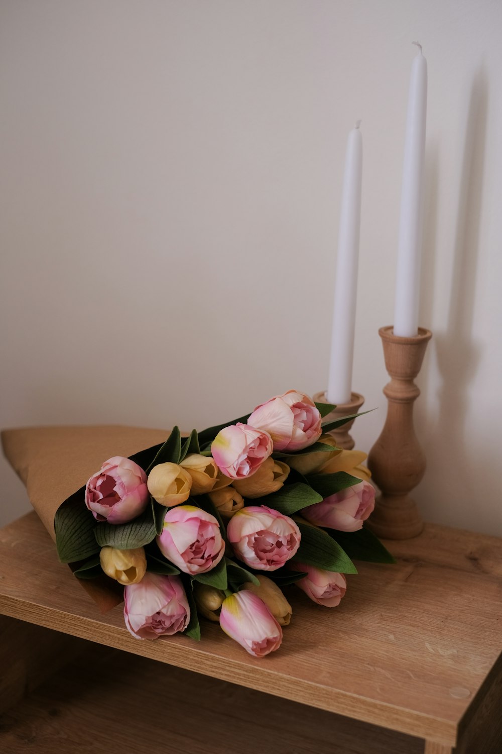 a bouquet of flowers sitting on a table next to two candles