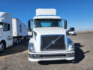 A fleet of modern trucks parked in an open lot.