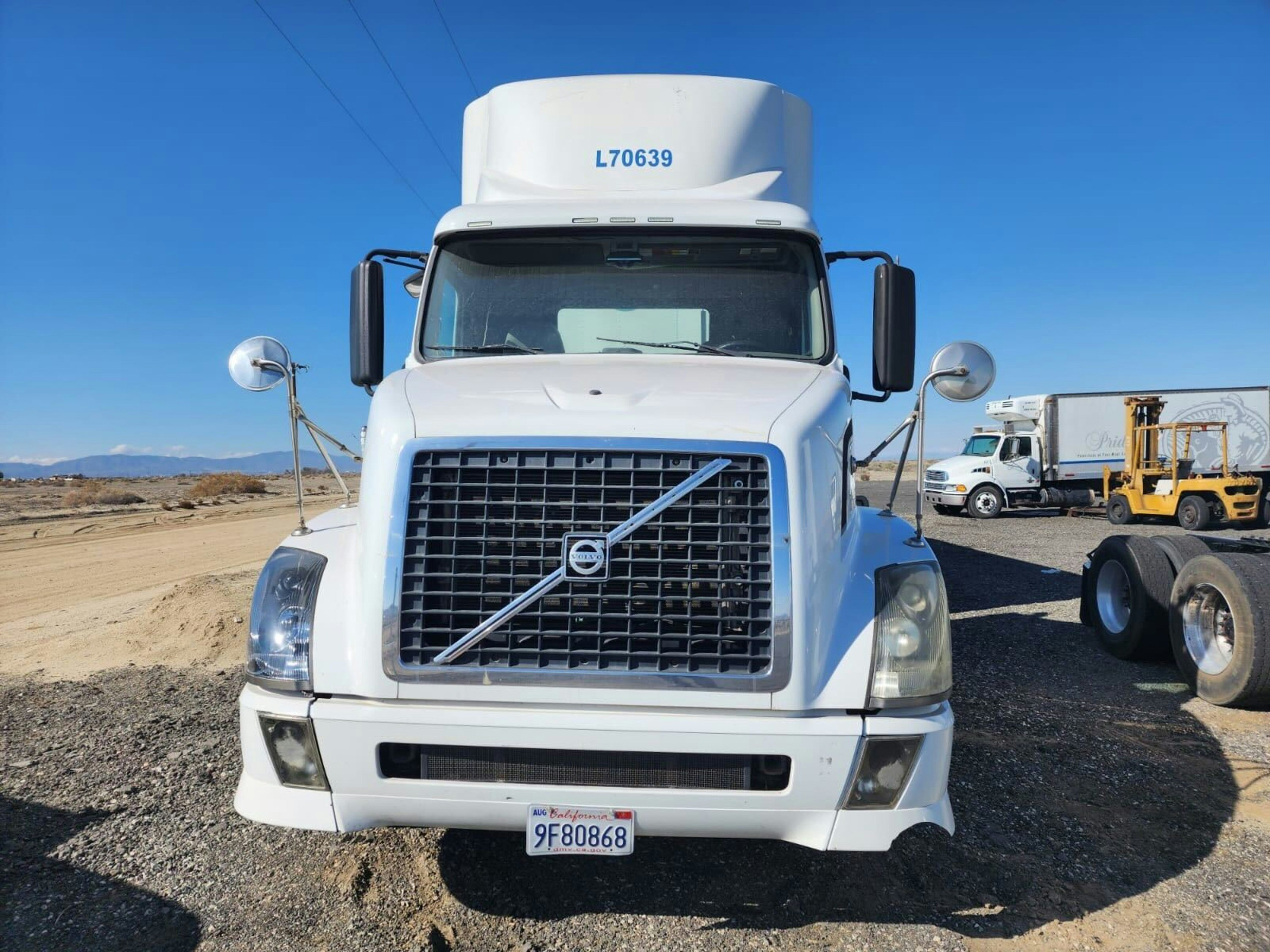 White tractor-trailer semi-truck being washed outdoors