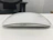 A stylish ergonomic mouse resting beside a laptop on a clean white surface.