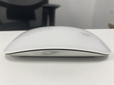 A sleek ergonomic computer mouse resting on a modern desk.