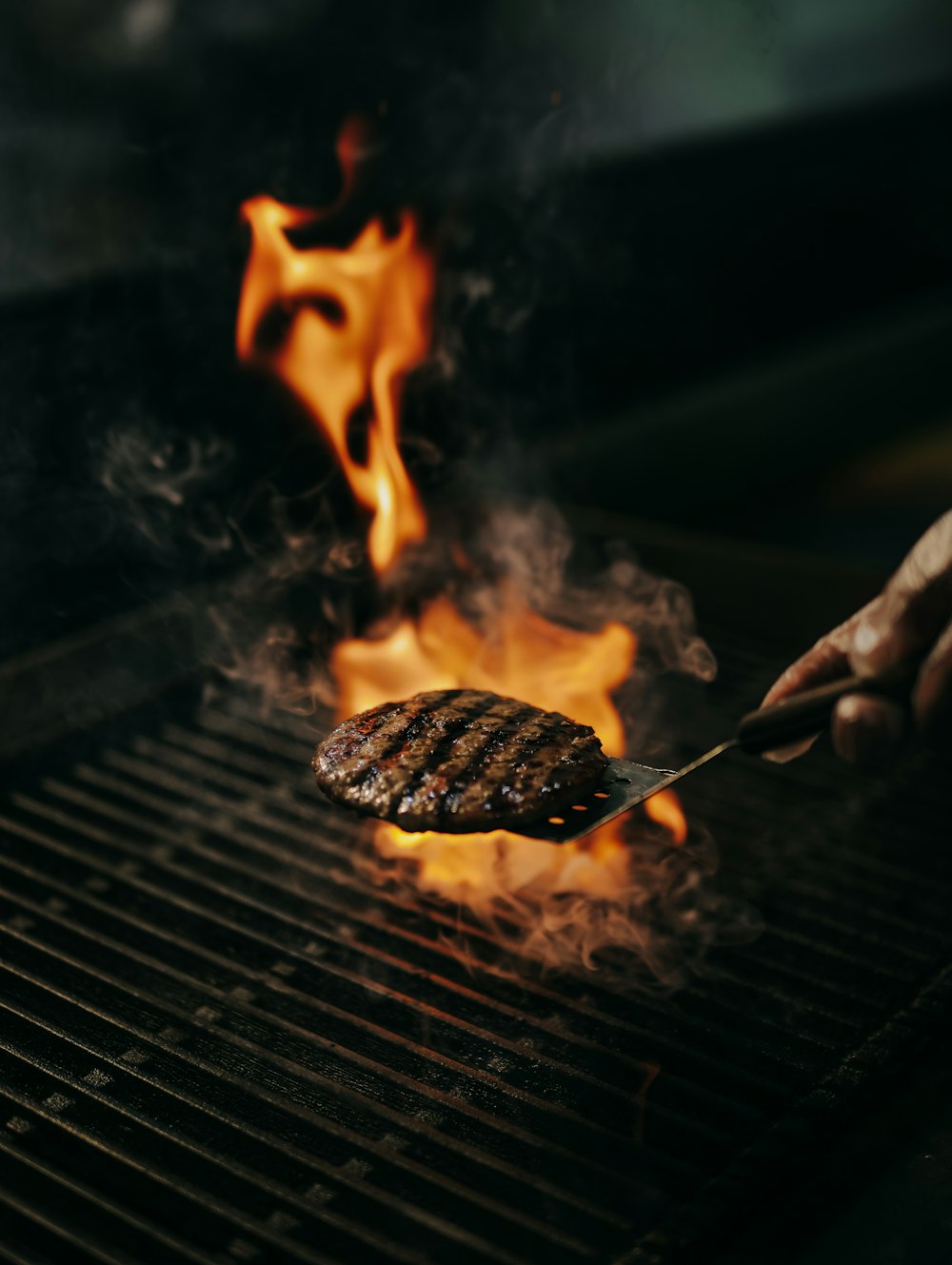 a person is grilling a hamburger on a grill