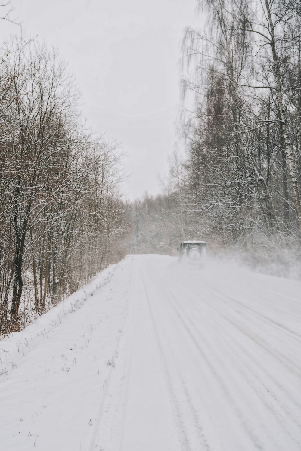 a truck driving down a snow covered road