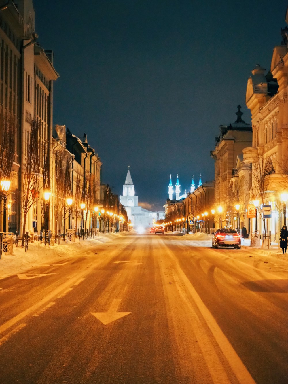 a city street at night with snow on the ground