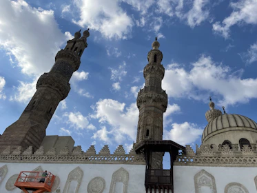 Close-up of a technician polishing a mosque's minaret finial with care.