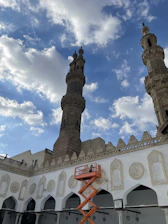 Close-up of damaged minaret concrete being carefully repaired by an expert climber.