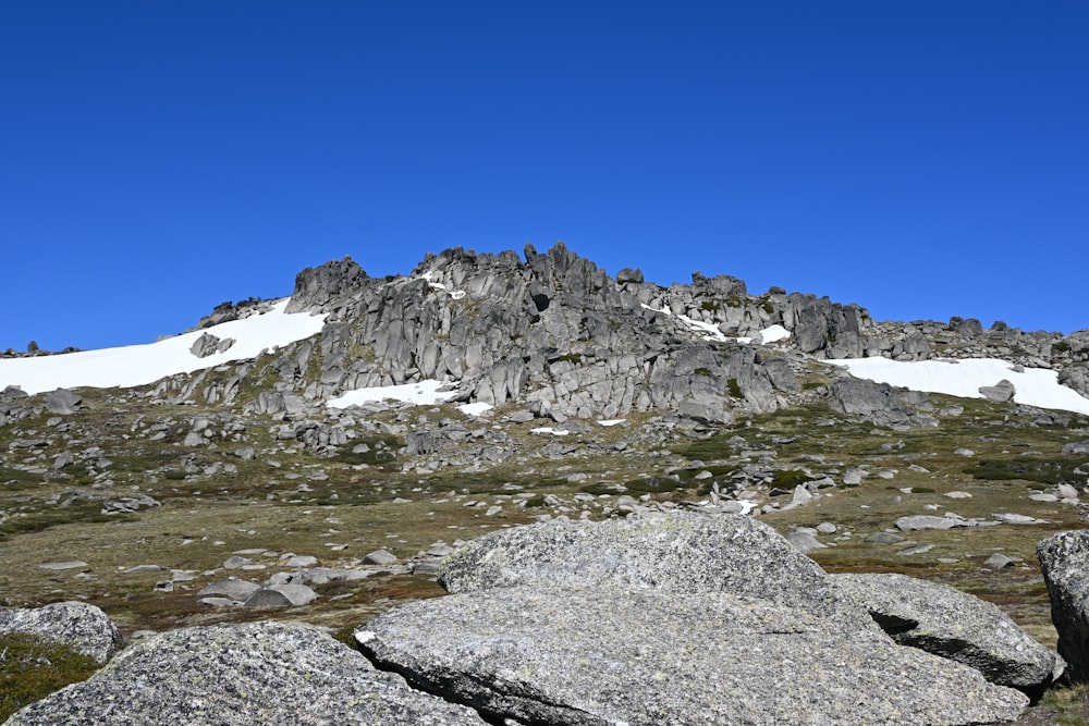 a rocky mountain with snow on the top