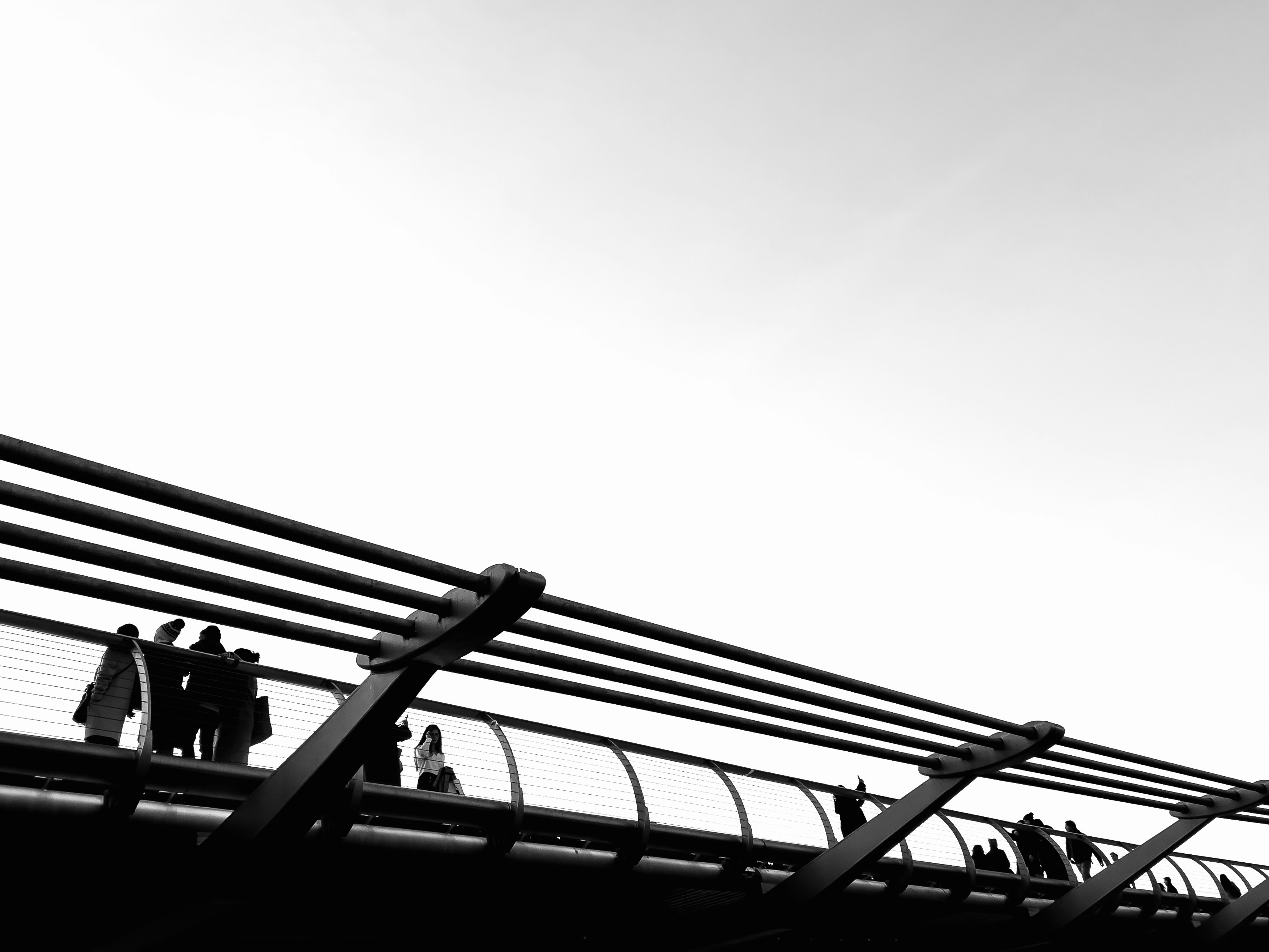 a group of people walking across a bridge
