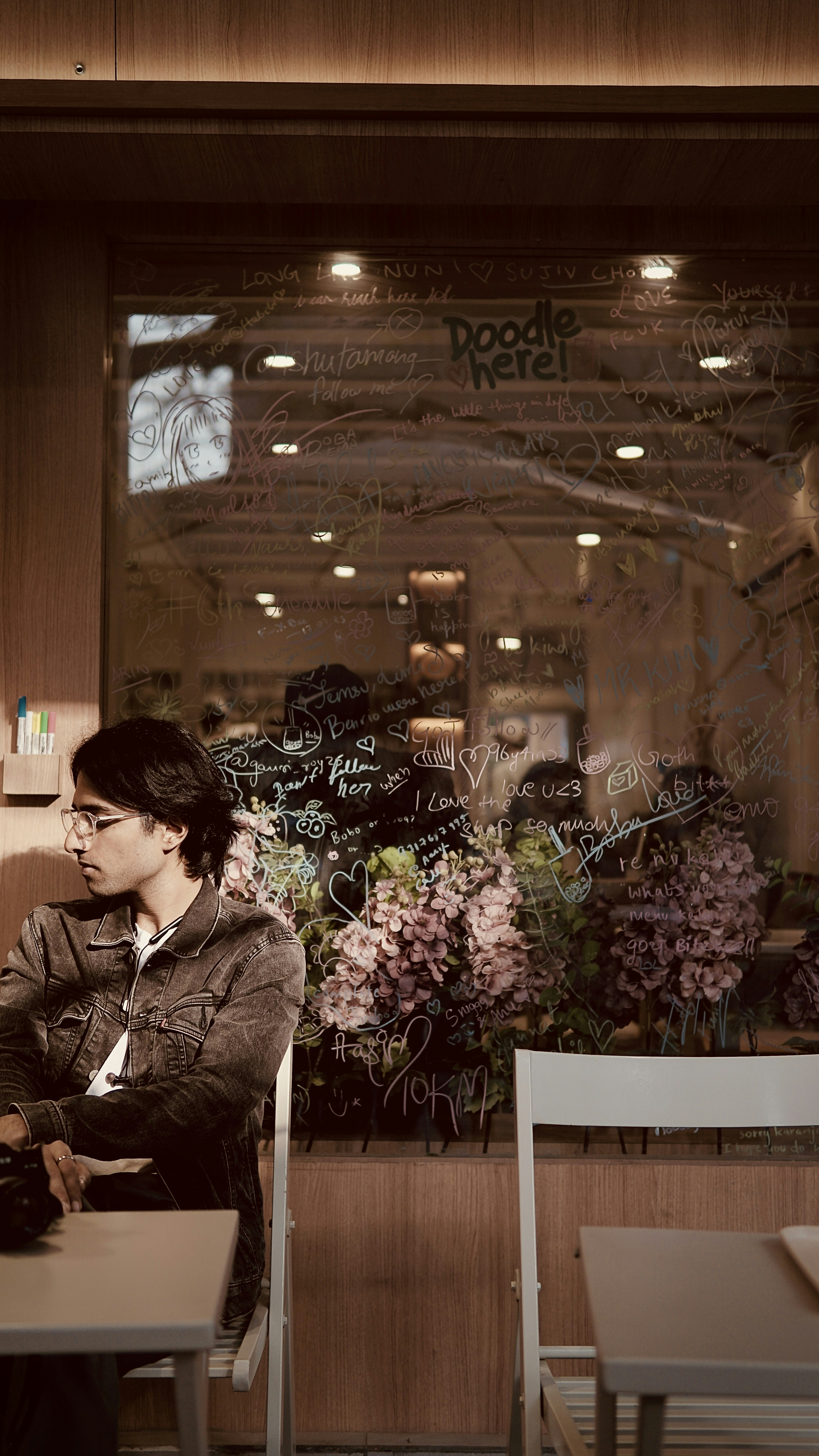 a woman sitting at a table in front of a window