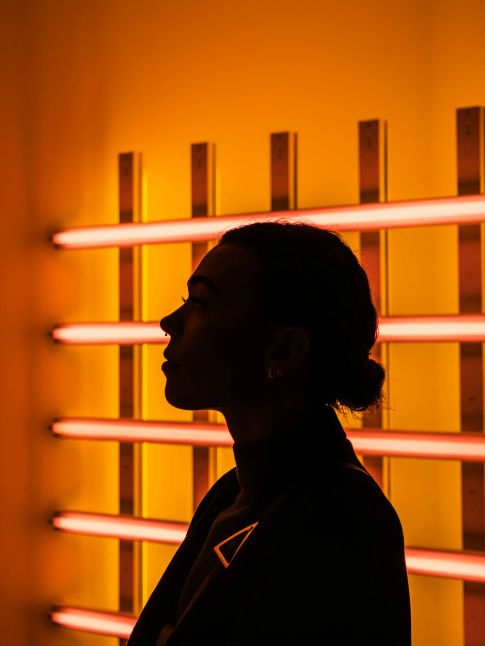 a woman standing in front of a yellow wall