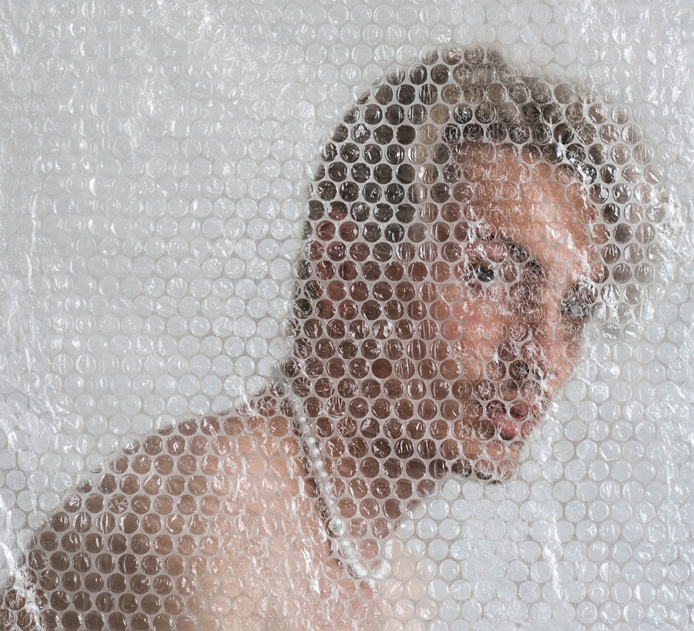 a man is seen through a mesh curtain