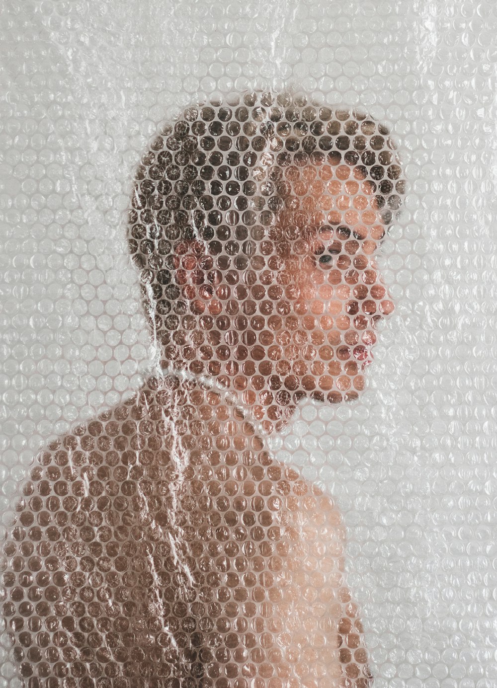 a young man is seen through a mesh curtain