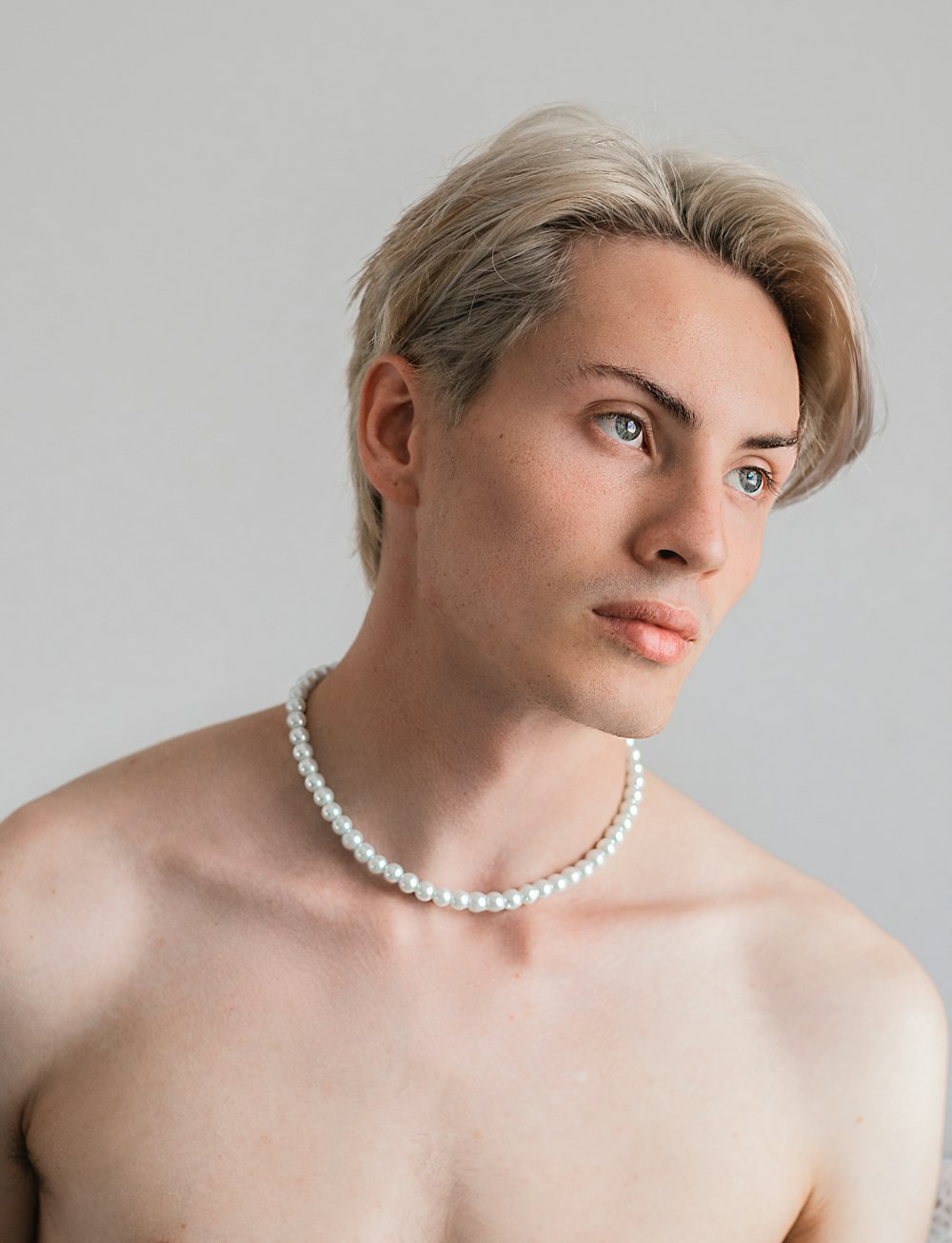 a man with a pearl necklace on his neck