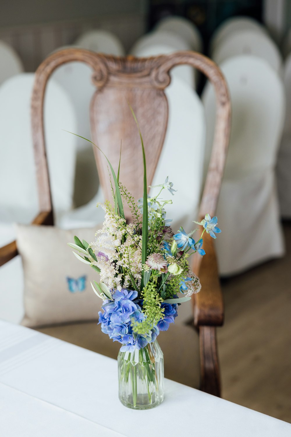 eine Vase gefüllt mit blauen und weißen Blumen auf einem Tisch