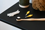 a toothbrush, toothpaste, and a teddy bear on a table