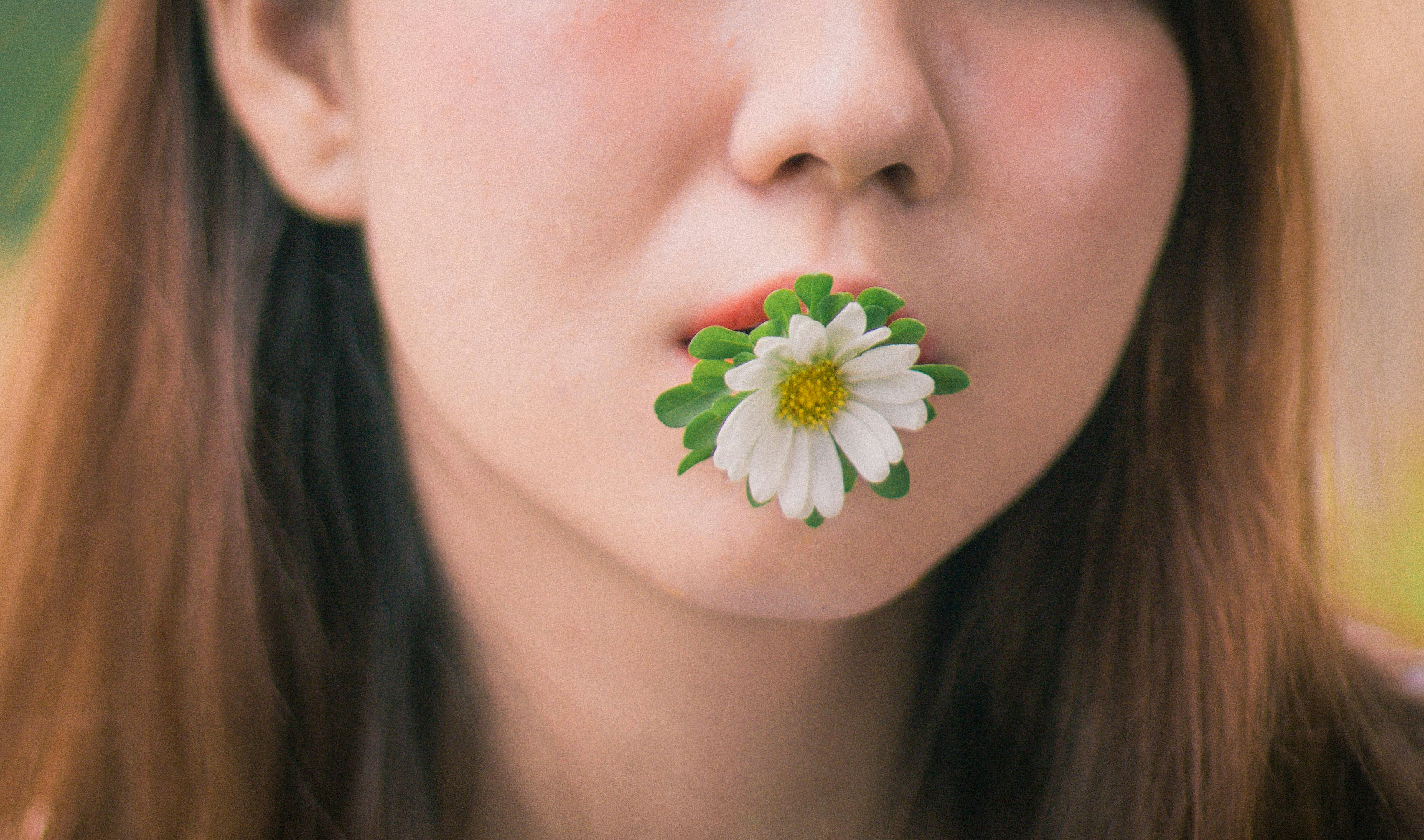 a woman with a flower in her mouth