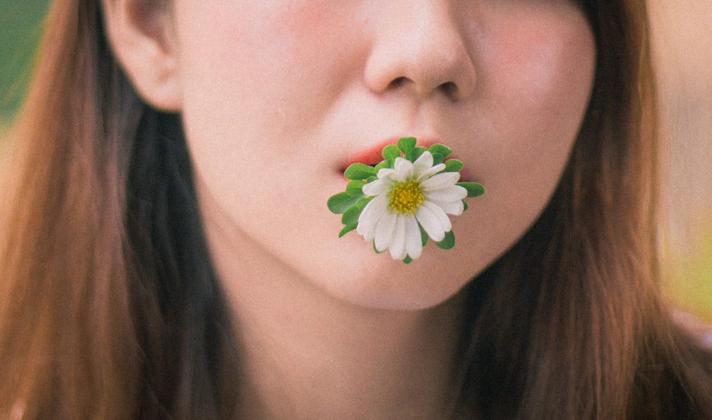 a woman with a flower in her mouth