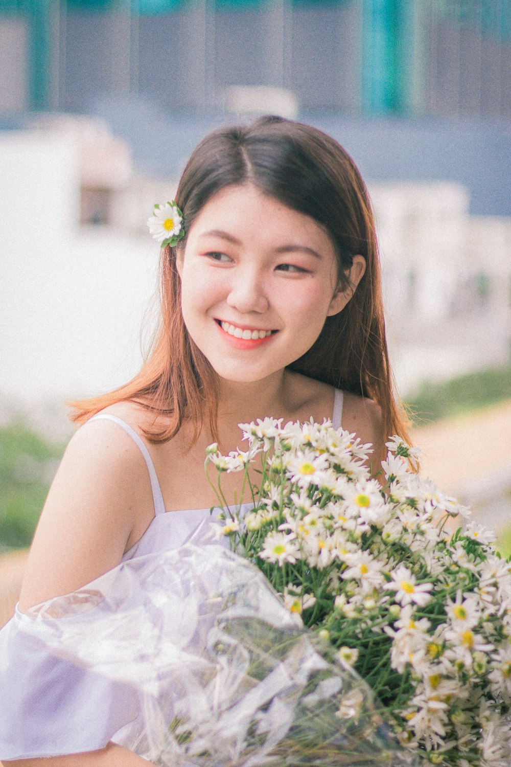 a young woman holding a bouquet of daisies