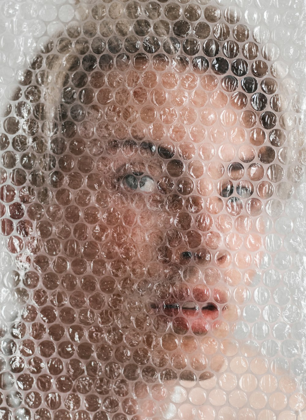 a woman's face through a meshed window