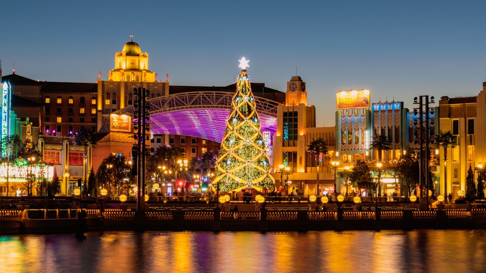 a lit christmas tree in the middle of a city