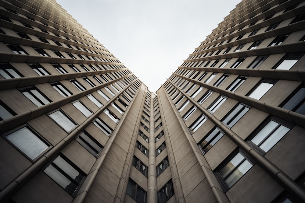 looking up at two tall buildings with windows
