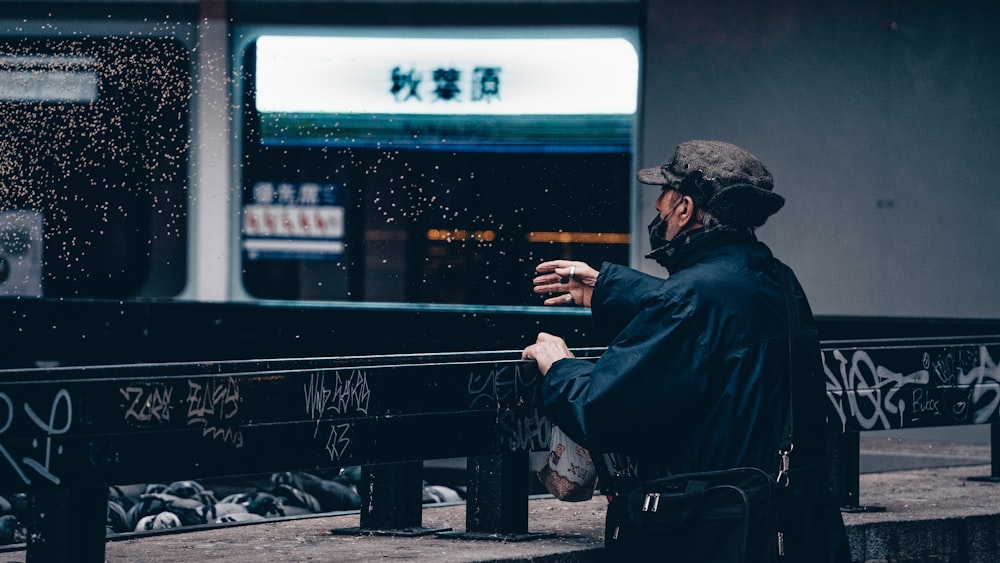 a man sitting on a bench in the rain