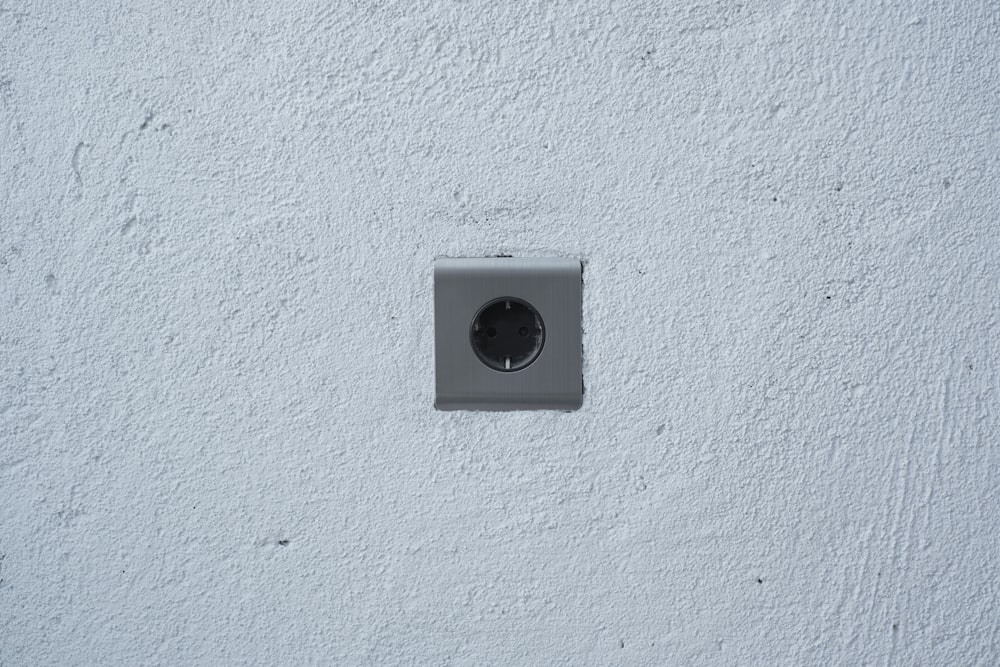 a white wall with a black and white light switch