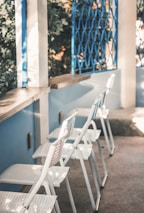 A foldable outdoor recliner set up on a sunny patio with a countertop storage rack nearby.