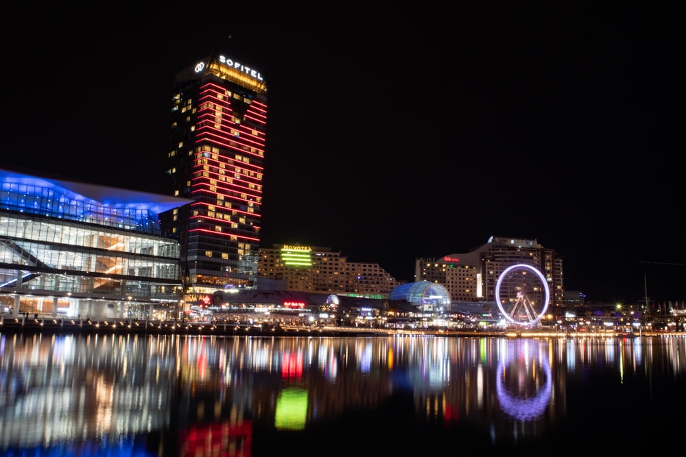 a city skyline with a ferris wheel lit up at night