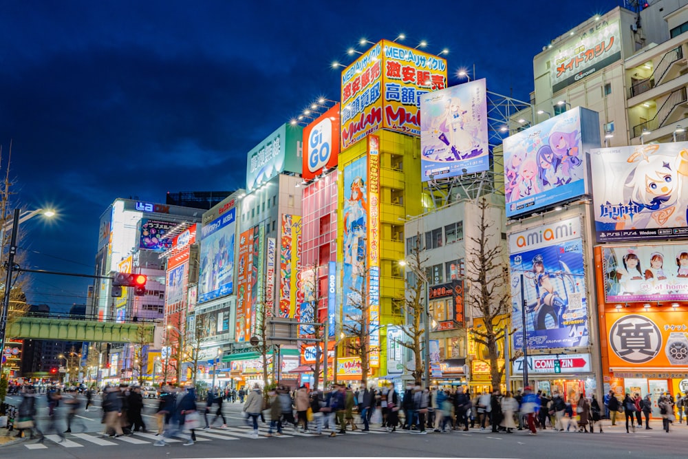 a crowded city street at night with people crossing the street