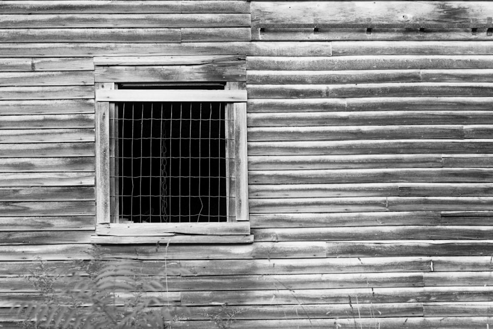 Una foto en blanco y negro de una ventana en un edificio de madera