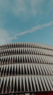 Photo of a mid-rise building with newly installed metal panel façade under clear blue sky.