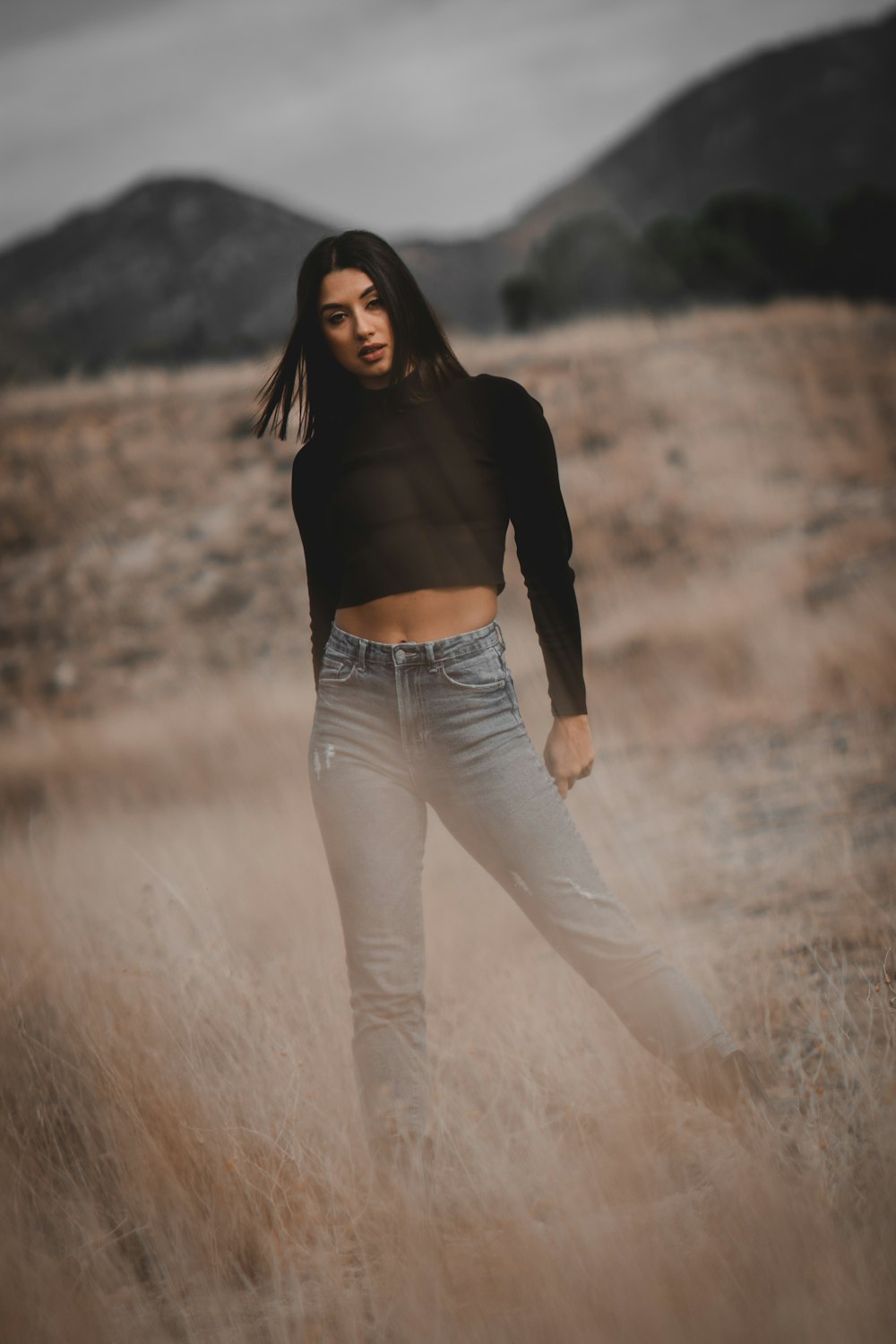 a woman standing in a field of tall grass