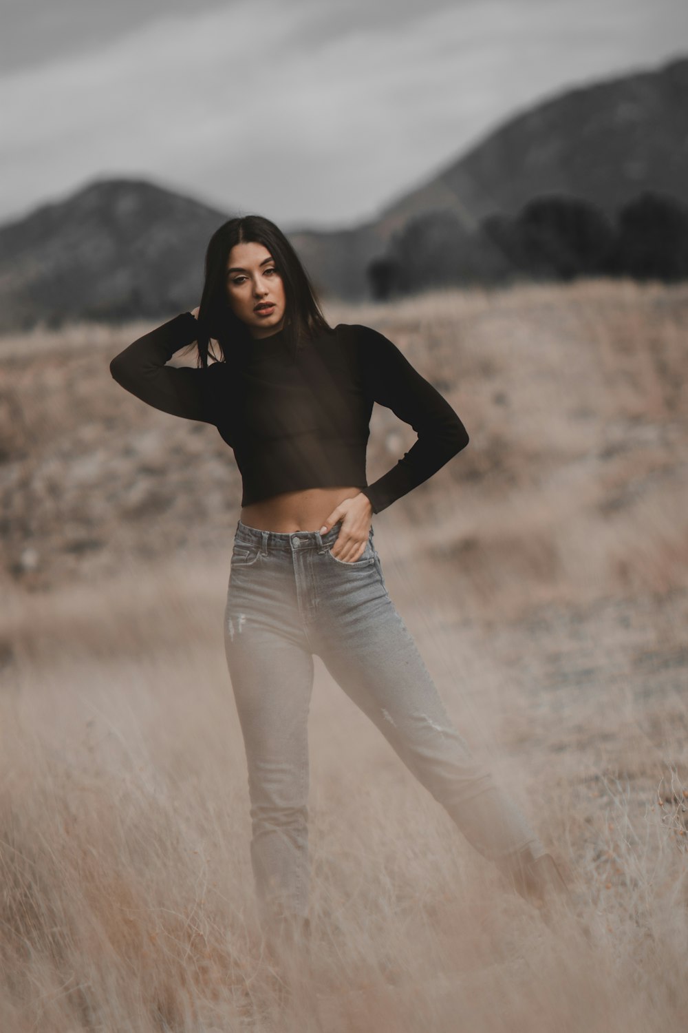 a woman standing in a field with her hands on her hips