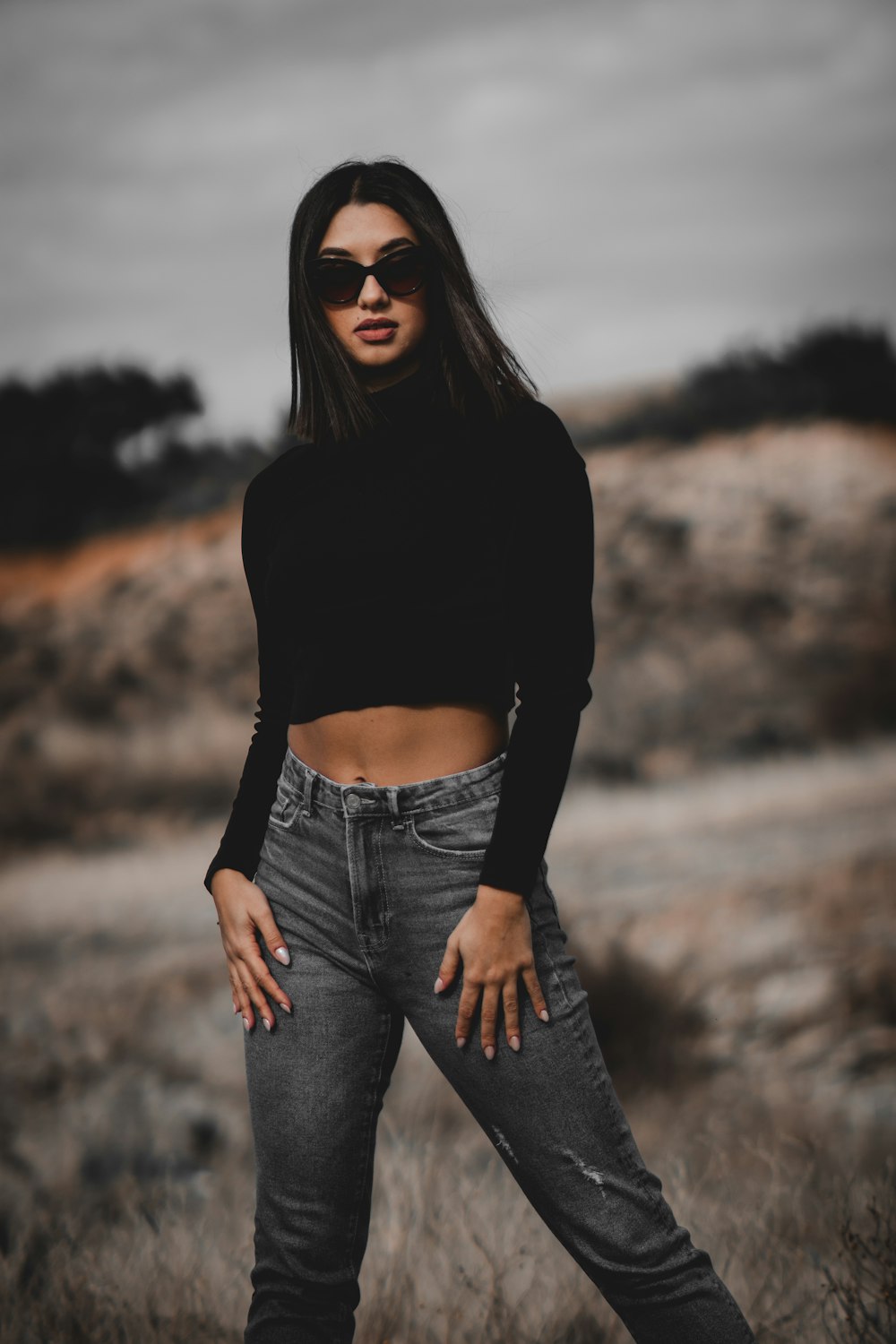 a woman in black shirt and jeans posing for a picture