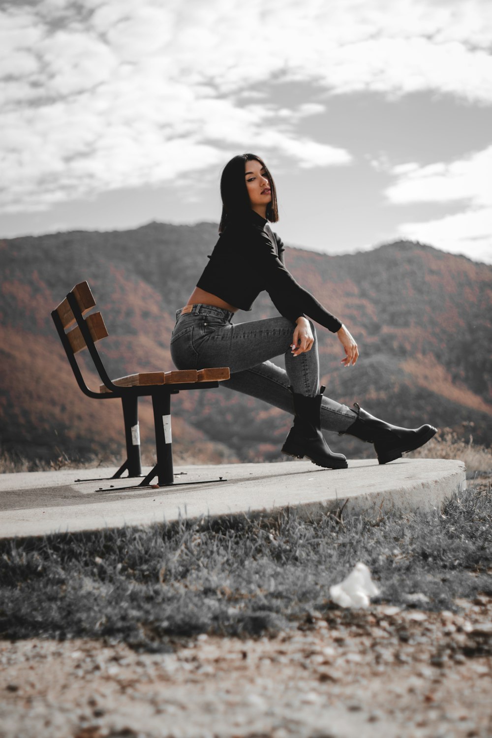 a woman sitting on top of a wooden bench