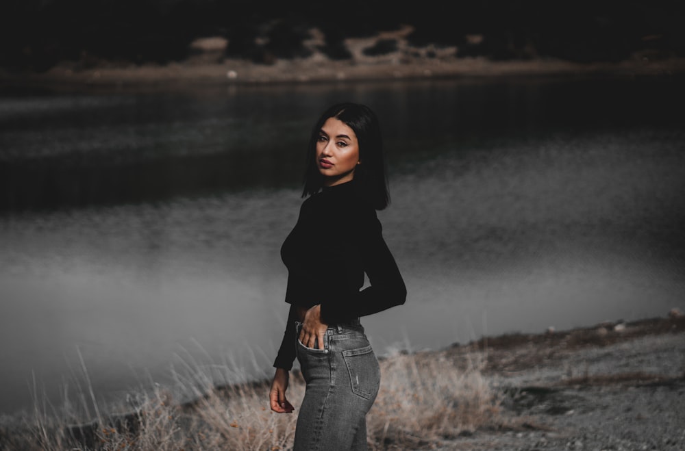 a woman standing in front of a body of water