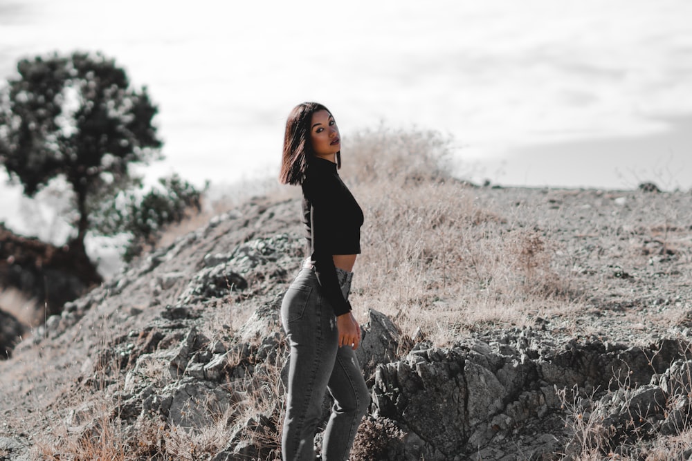 a woman standing on top of a rocky hillside