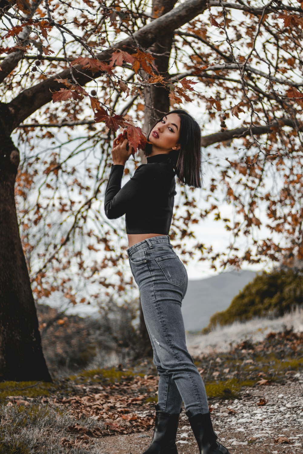 a woman standing in front of a tree