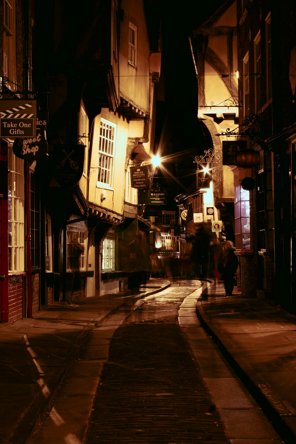 a dark alley with people walking down it at night