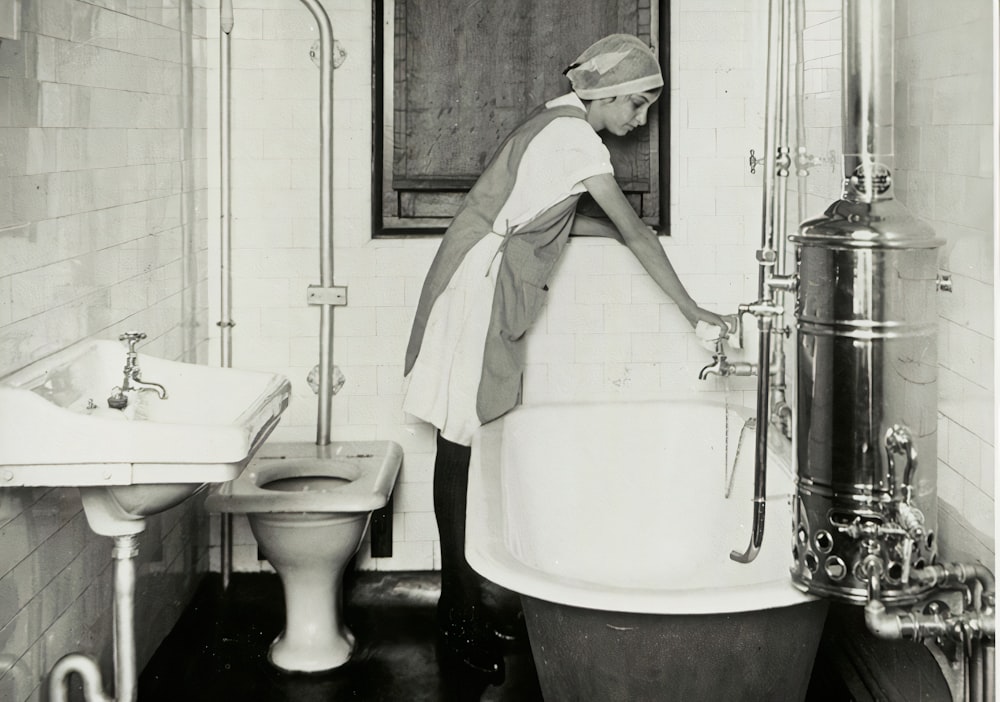 uma foto em preto e branco de uma mulher em um banheiro