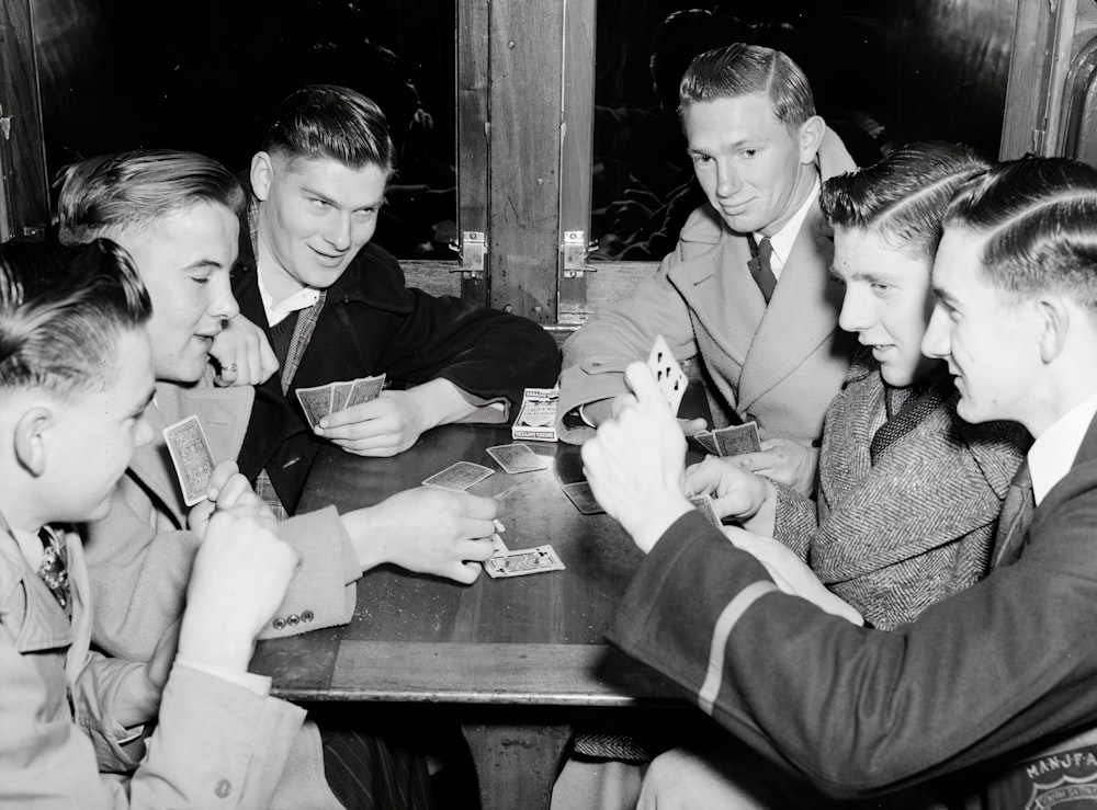 a group of men sitting around a table playing cards