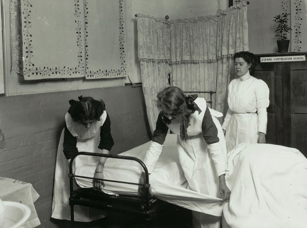 uma foto em preto e branco de uma mulher em uma cama de hospital