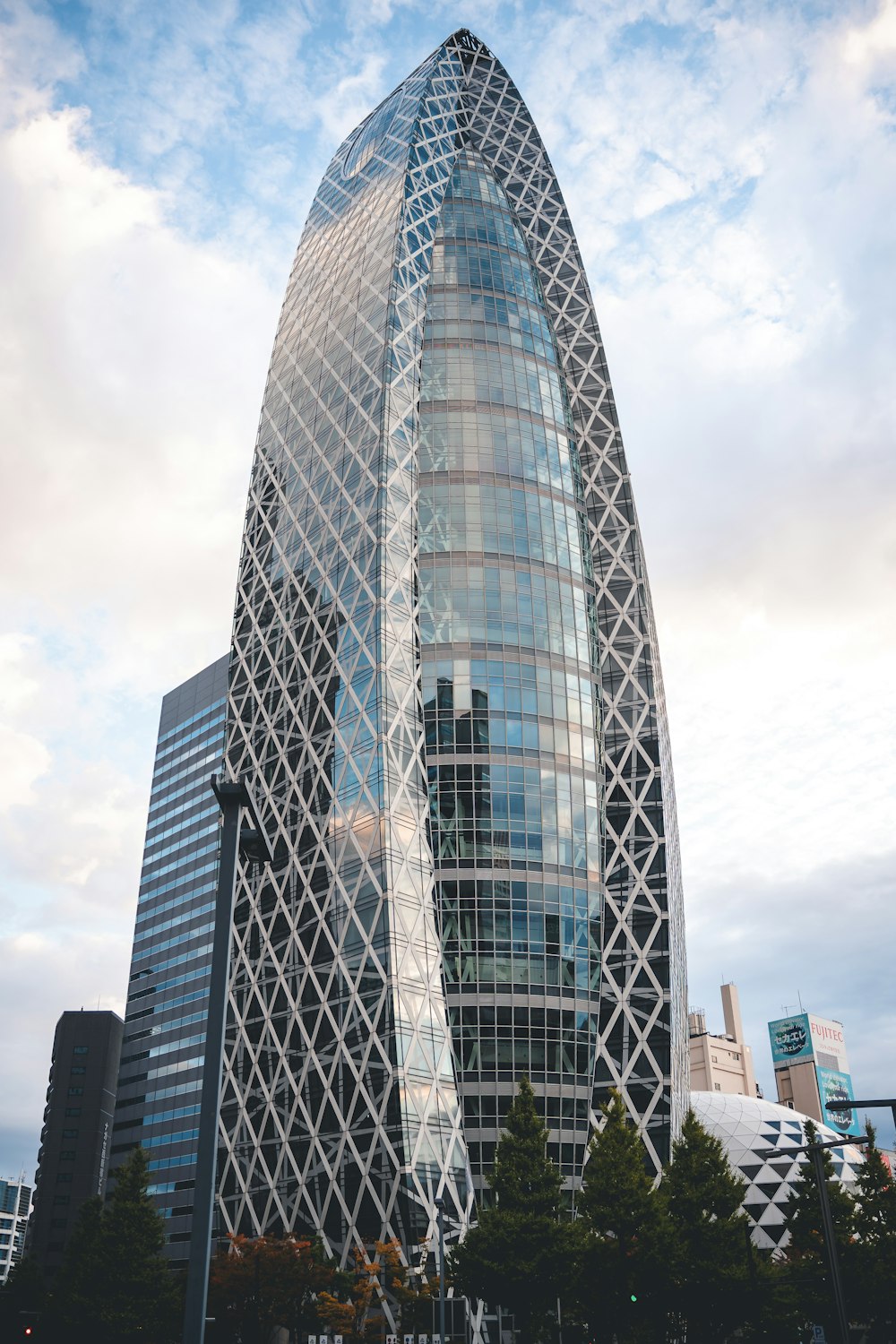 a very tall glass building with a sky background