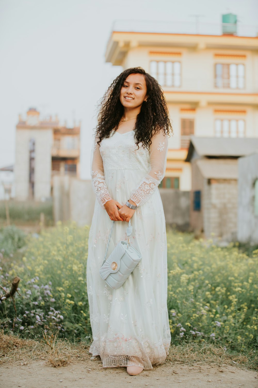 a woman in a white dress holding a blue purse