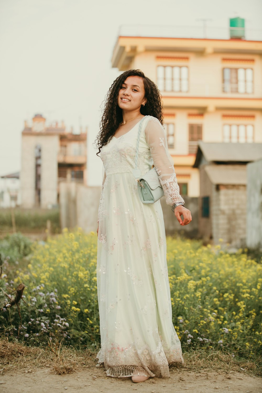 a woman in a white dress standing in front of a building