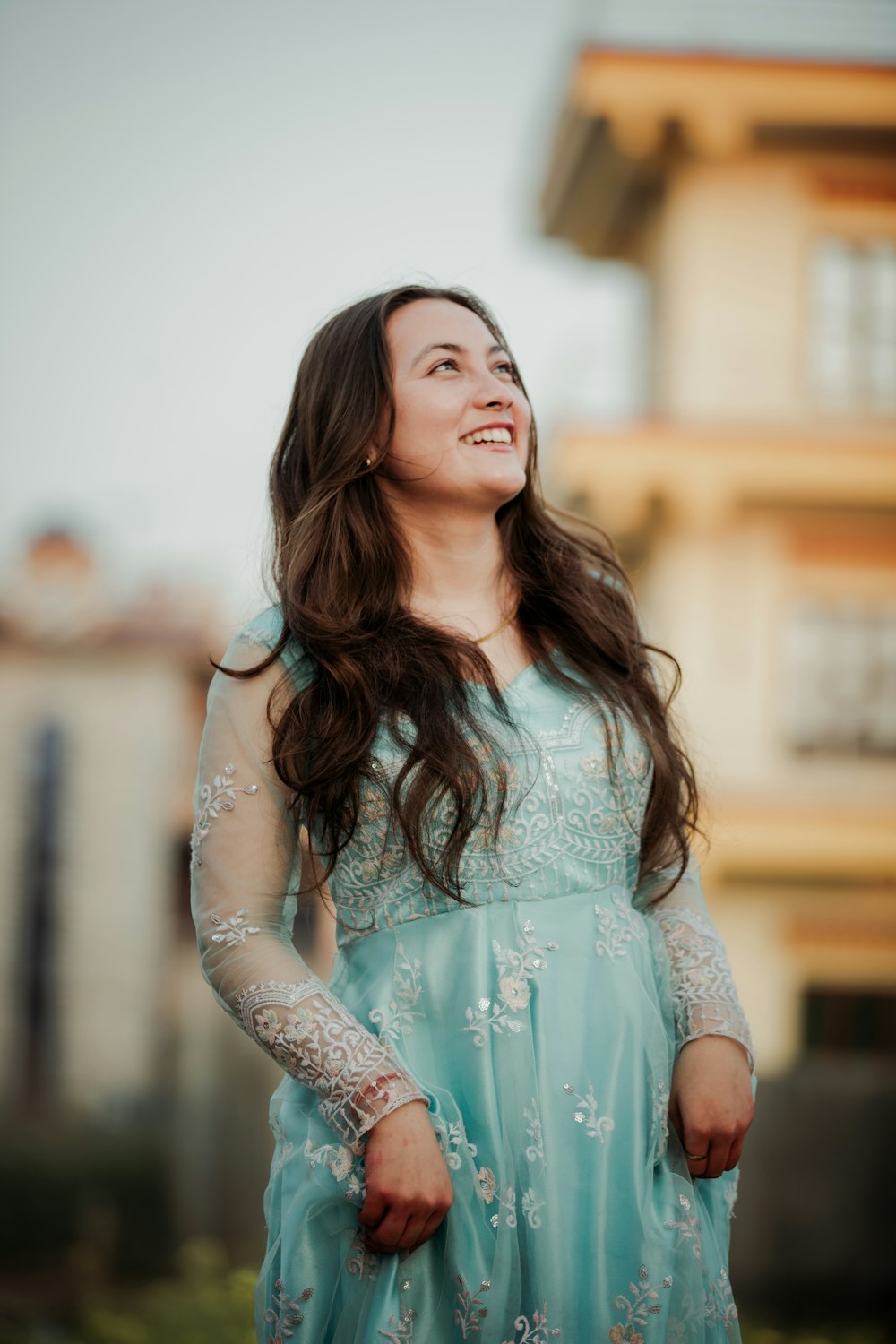 a woman in a blue dress standing in front of a building