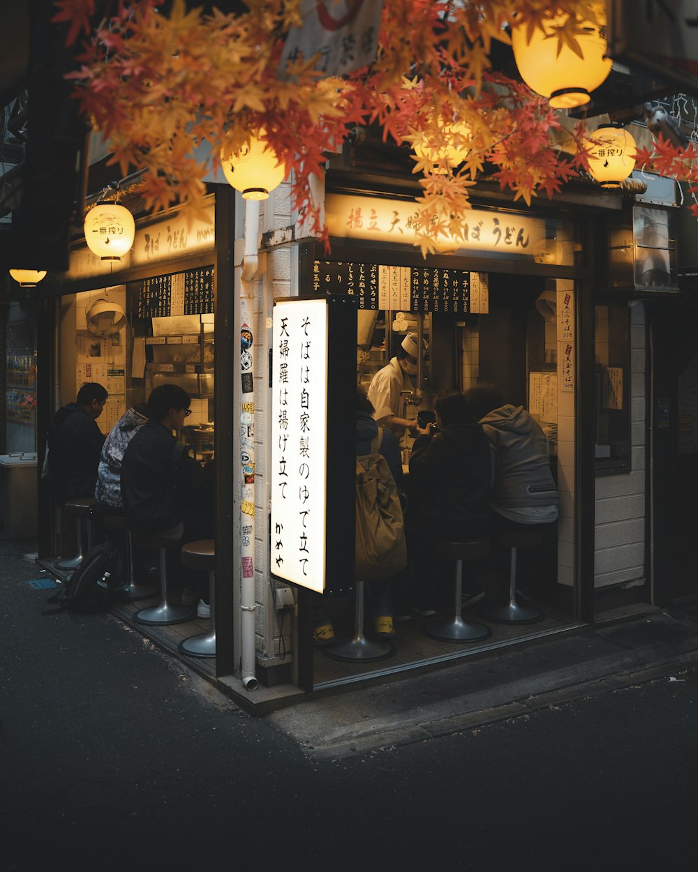 a group of people sitting outside of a restaurant